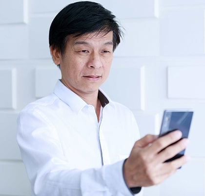 Man with hyperopia looking at smartphone